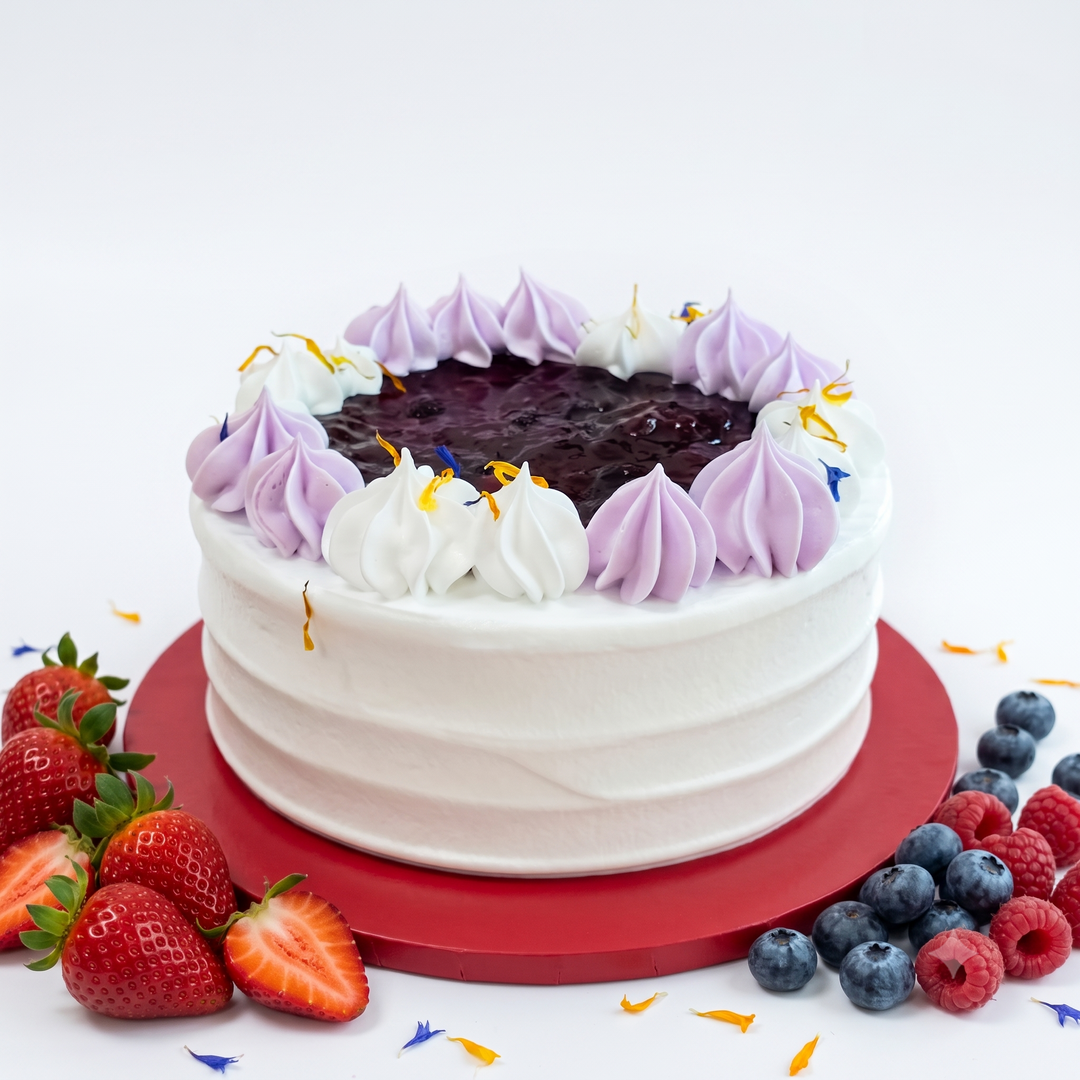 A whole Vegan Mixed Berries Cake with vanilla sponge, plant cream, and fresh berries by SK Homemade Cakes.