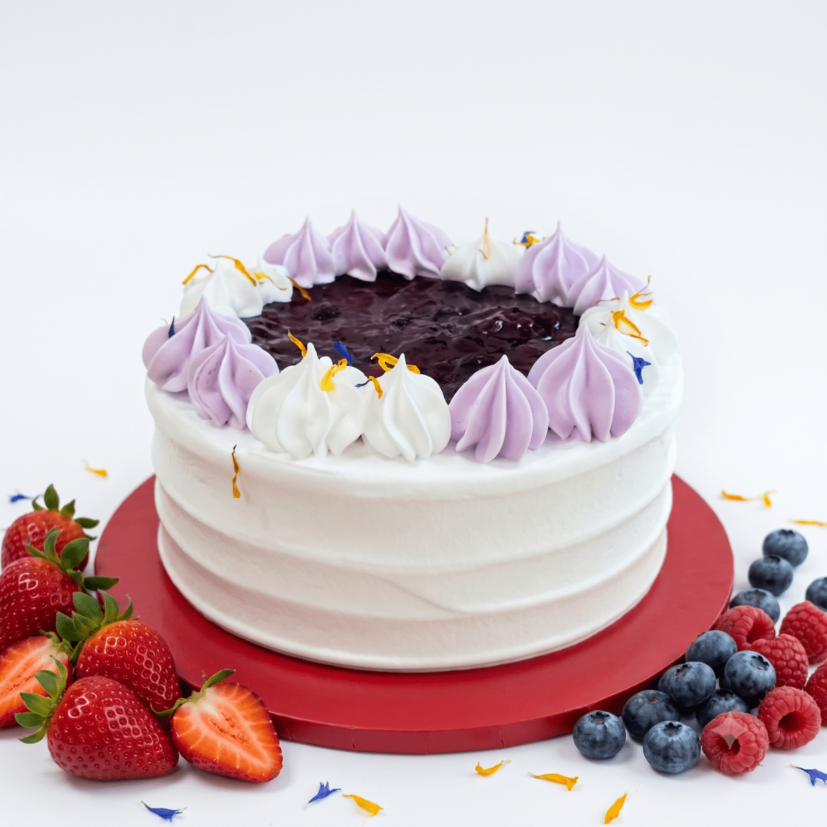 A whole Vegan Mixed Berries Cake with vanilla sponge, plant cream, and fresh berries by SK Homemade Cakes.